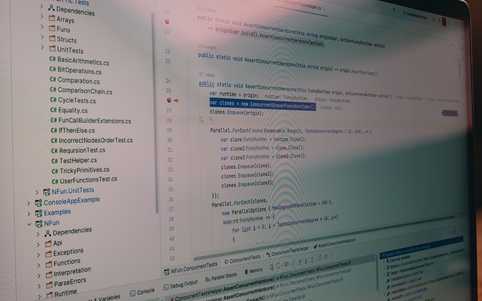 Laptop screen showing C# code with a solution explorer and concurrent test functions